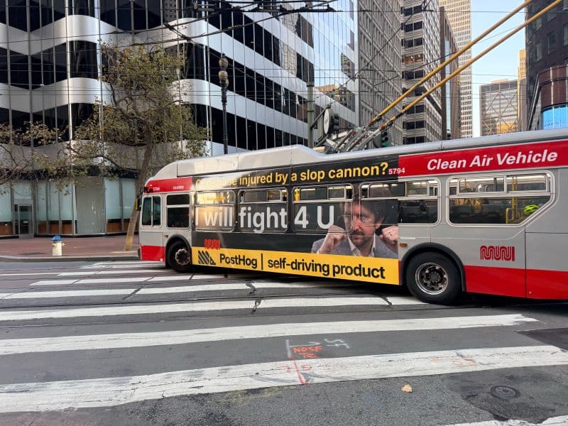 San Francisco Muni bus wrapped in a PostHog 'self-driving product' AI advertisement