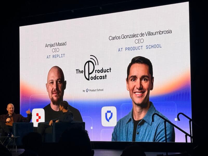 The Product Podcast on stage, with Replit CEO Amjad Masad and Product School CEO Carlos Gonzalez de Villaumbrosia on screen